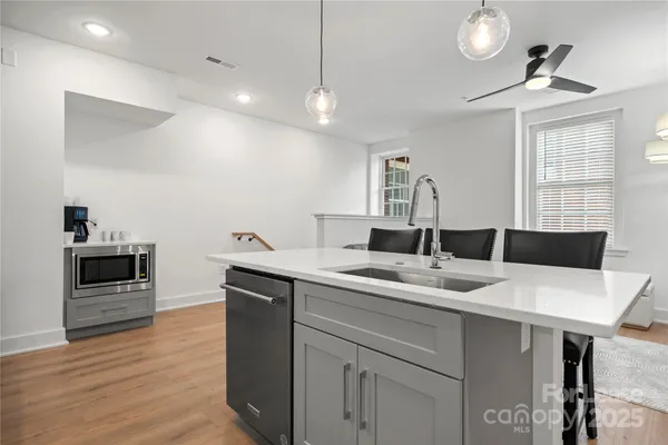 a kitchen with a sink cabinets and wooden floor