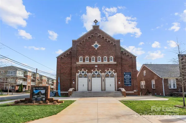 a front view of a building with a garden and plants