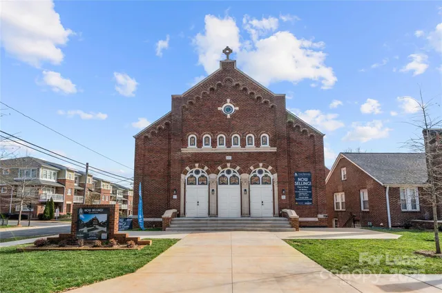 a front view of a building with a garden and plants
