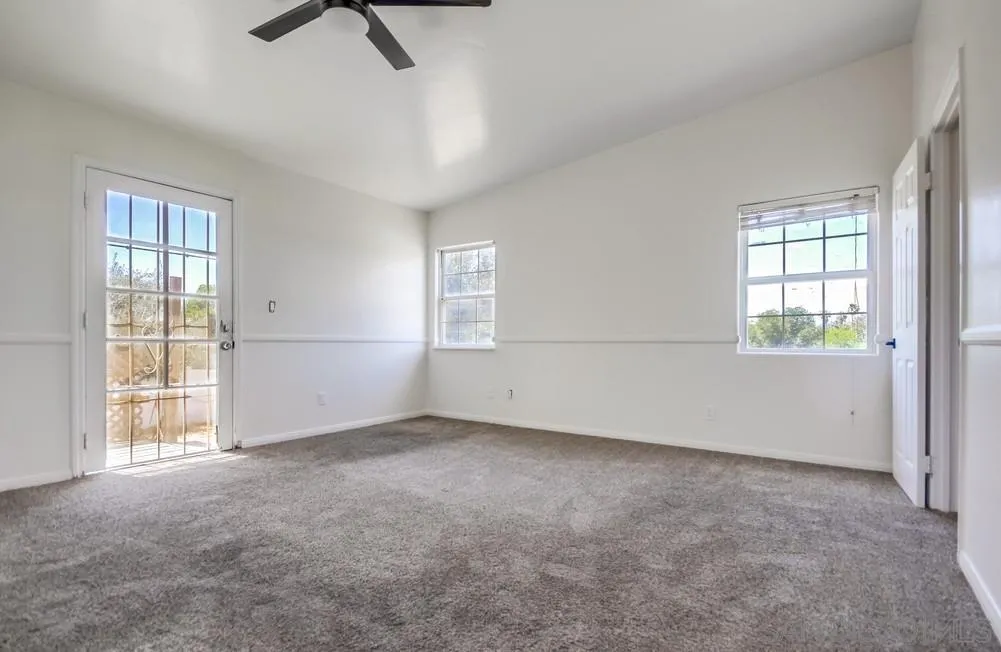 12224 Lemon Crest Drive Lakeside, CA 92040 - Photo 23 of 61 an empty room with windows and chandelier fan