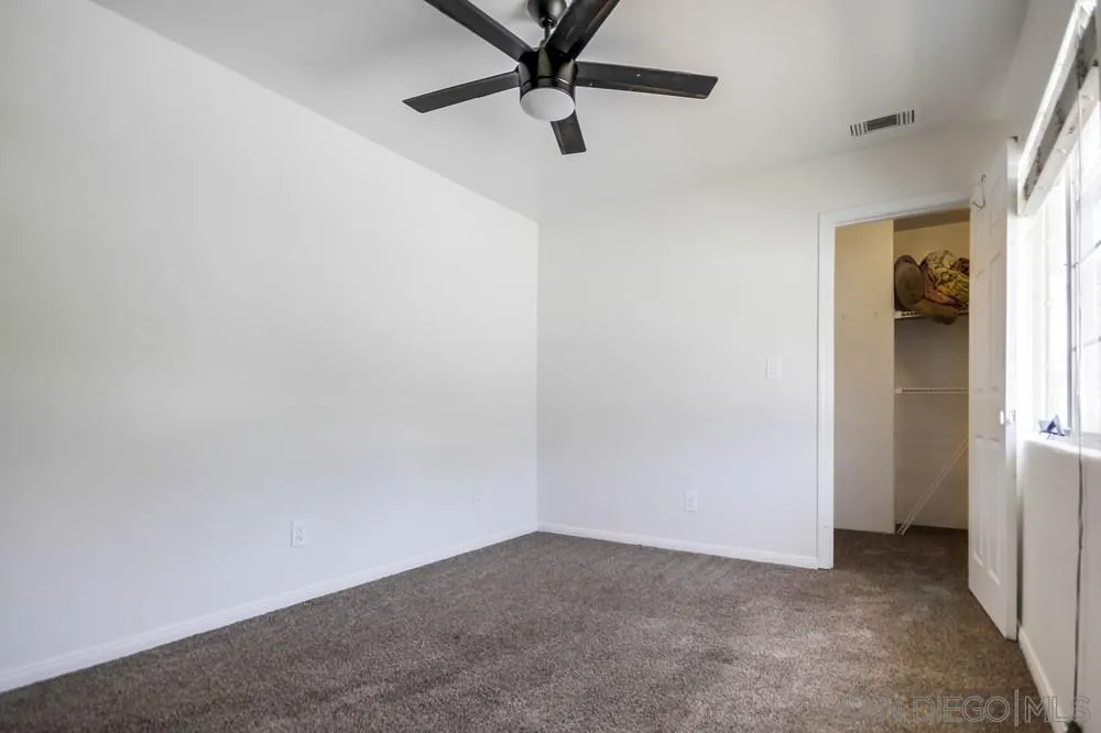 12224 Lemon Crest Drive Lakeside, CA 92040 - Photo 39 of 61 an empty room with a ceiling fan and window