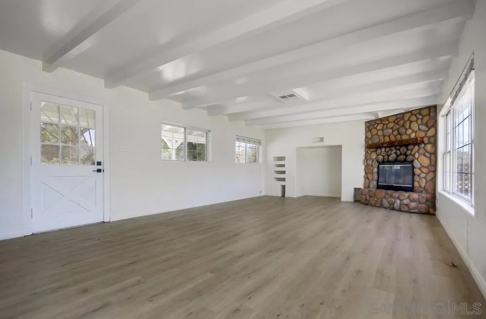12224 Lemon Crest Drive Lakeside, CA 92040 - Photo 8 of 61 an empty room with wooden floor fireplace and windows