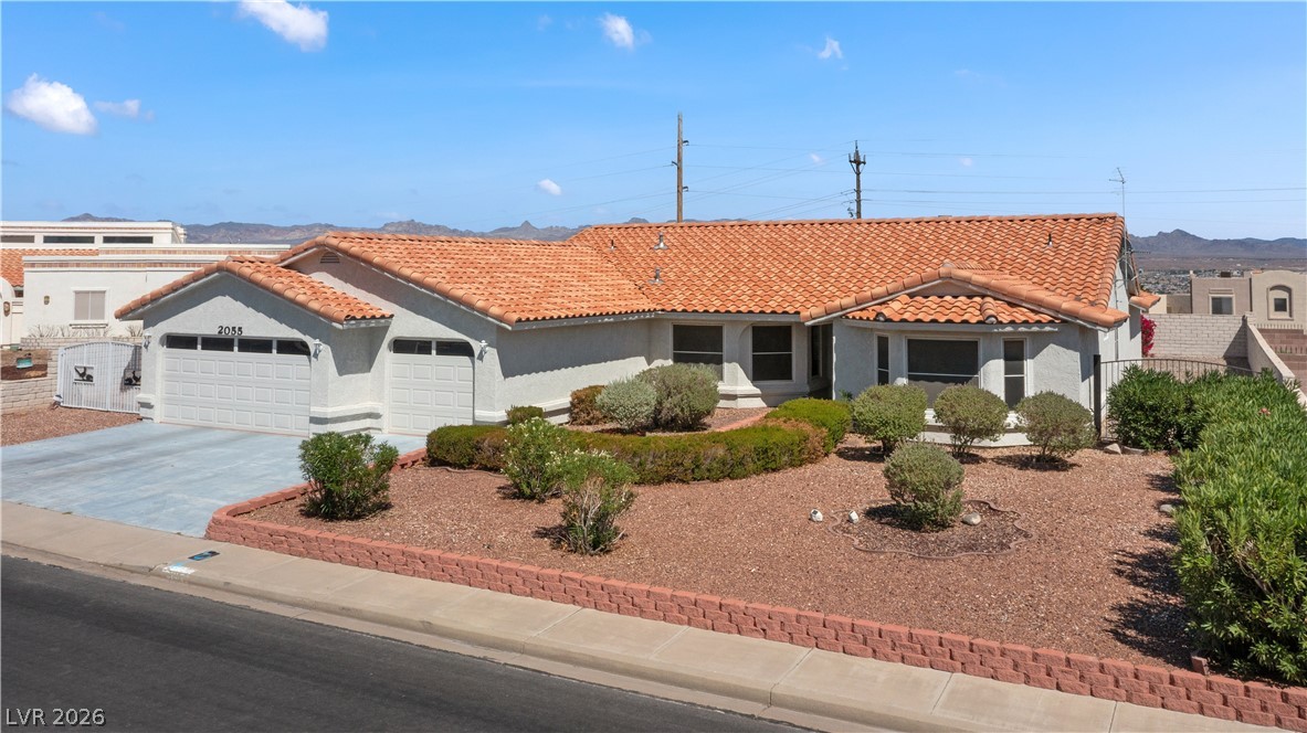 2055 Cholla Way Laughlin, NV 89029 - Photo 68 of 87 A terracotta-tiled roof crowns this residence with a well-maintained xeriscape yard and attached garage.