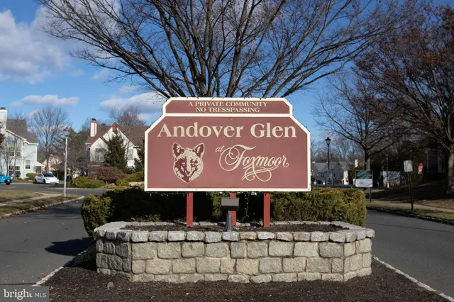 a view of an empty room with wooden floor fireplace and a window