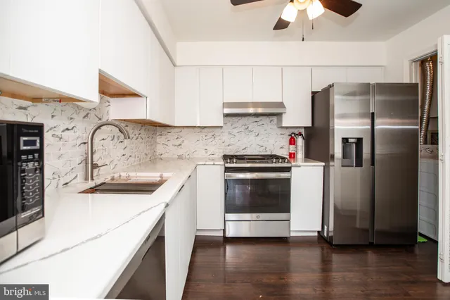 a kitchen with granite countertop a sink a stove and microwave