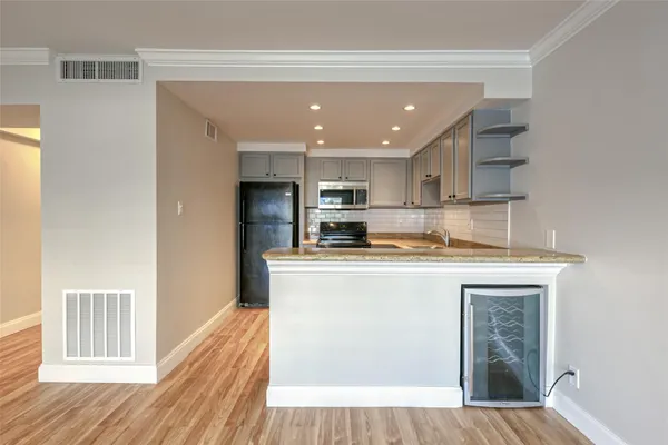 a kitchen with granite countertop a stove sink and microwave