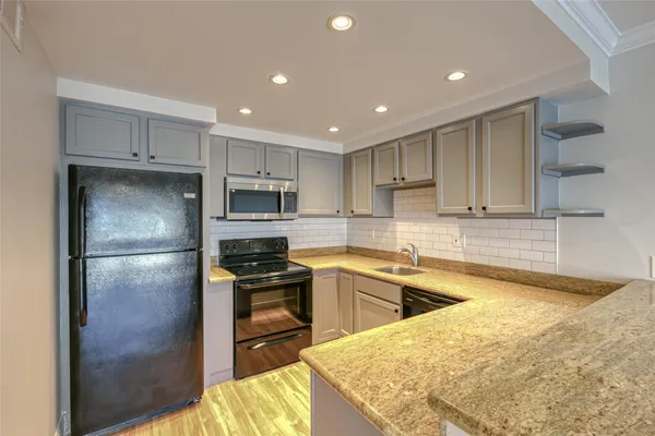 a kitchen with stainless steel appliances granite countertop a stove and a sink