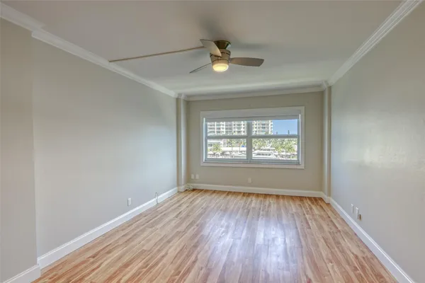 a view of empty room with wooden floor