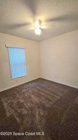 an empty room with a chandeliers fan