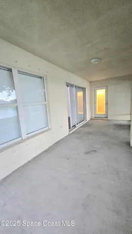 an empty room with a fireplace and windows