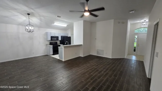 a view of a kitchen with wooden floor and electronic appliances