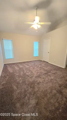 en empty room with windows and fan