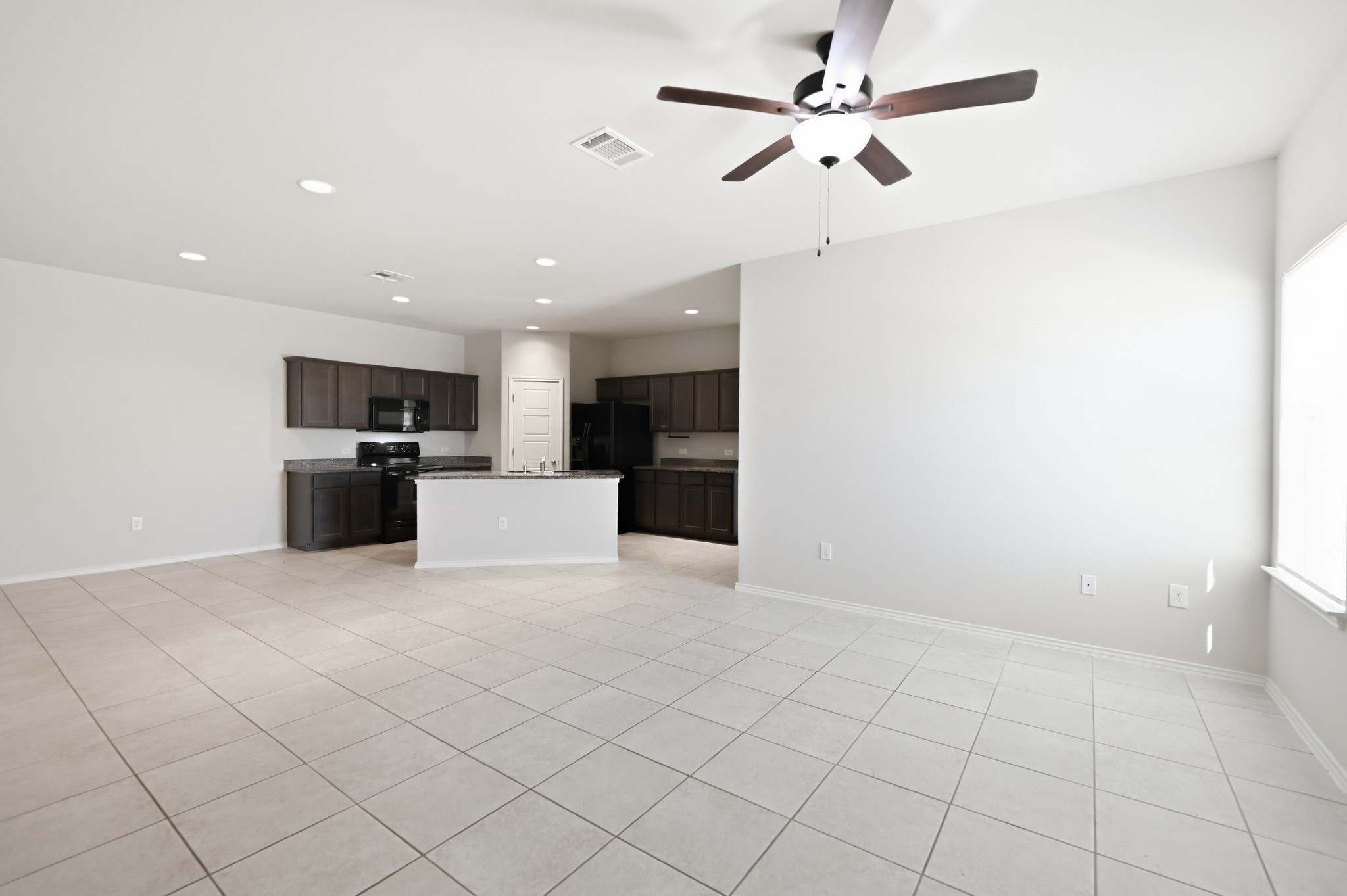 An open layout connects the tiled living space directly to the kitchen area.