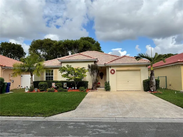 a front view of a house with a yard and trees