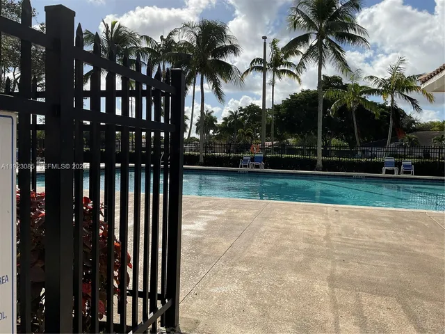 a view of swimming pool with palm trees