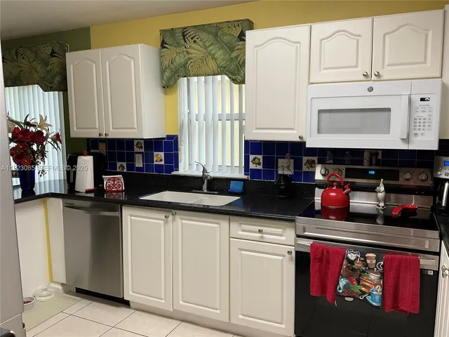 a kitchen with stainless steel appliances granite countertop a sink and cabinets