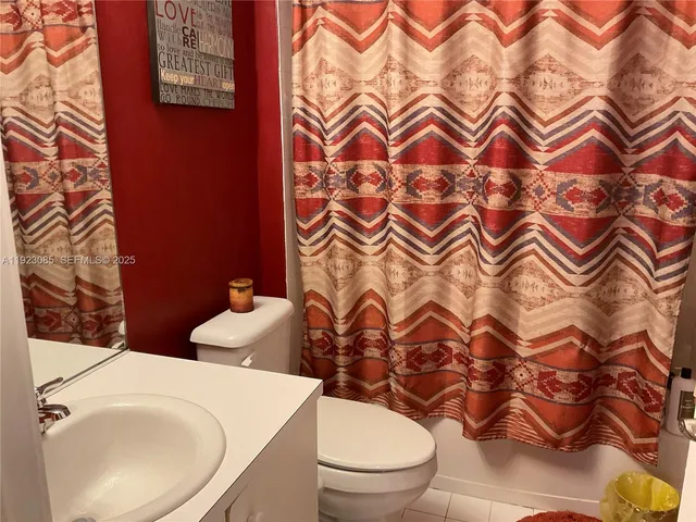 a white toilet sitting next to a shower curtain