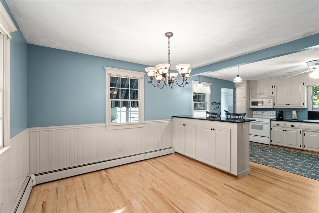 63 Pomeroy Street Easthampton, MA 01027 - Photo 20 of 42 a large white kitchen with granite countertop a stove a sink dishwasher and a refrigerator with wooden floor
