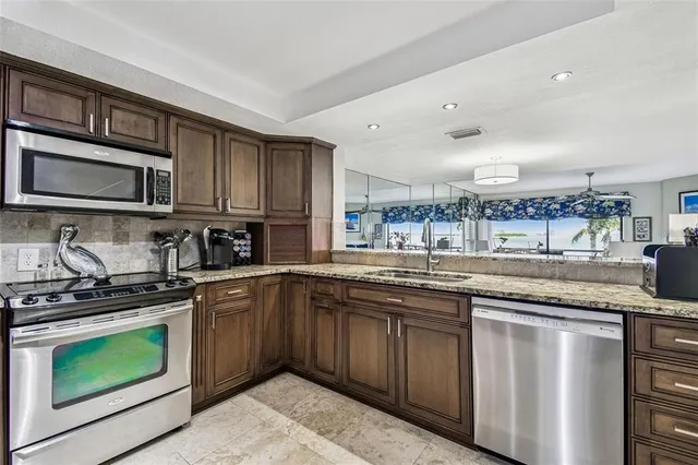 a kitchen with stainless steel appliances granite countertop a sink and stove top oven