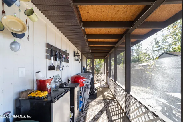 a living room with furniture two windows and wooden floor