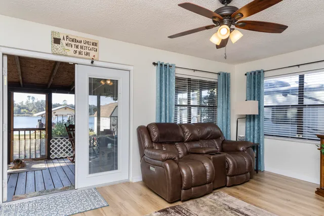 a living room with furniture a ceiling fan and a flat screen tv
