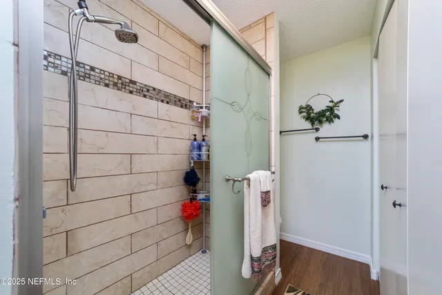 a spacious bedroom with a bed and dresser with mirror