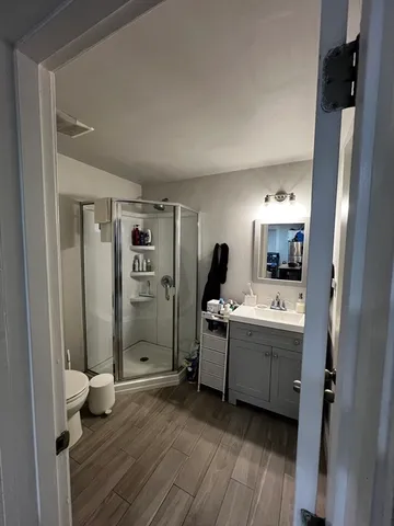 a view of kitchen with stainless steel appliances wooden floor and window