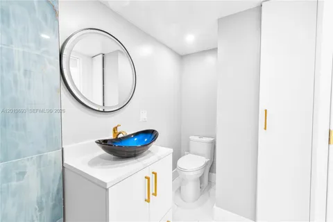 a bathroom with a sink a toilet and a mirror