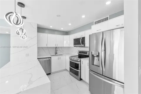 a kitchen with stainless steel appliances a refrigerator a sink and a stove