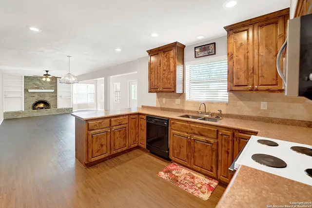 a large kitchen with stainless steel appliances granite countertop a stove a sink and a microwave