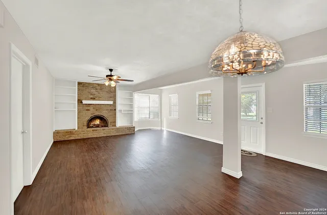 a view of a livingroom with wooden floor and a ceiling fan
