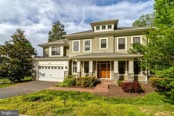 a front view of a house with yard and green space