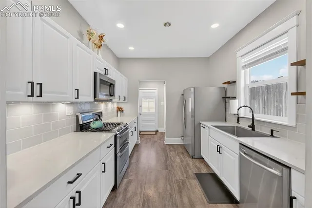 a kitchen with stainless steel appliances a sink stove and cabinets