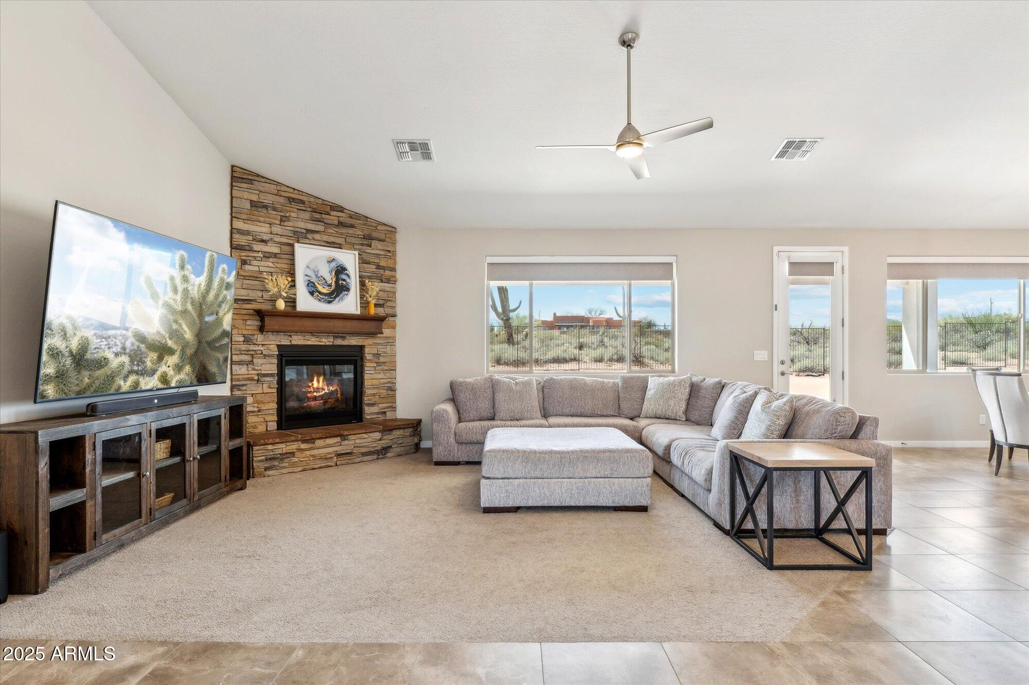 27420 North 170th Street Rio Verde, AZ 85263 - Photo 4 of 39 a living room with furniture a flat screen tv and a fireplace