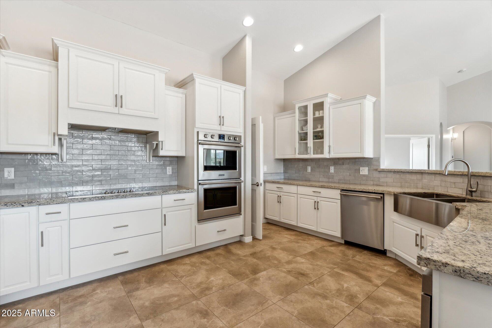27420 North 170th Street Rio Verde, AZ 85263 - Photo 7 of 39 a large kitchen with granite countertop a sink white cabinets and stainless steel appliances