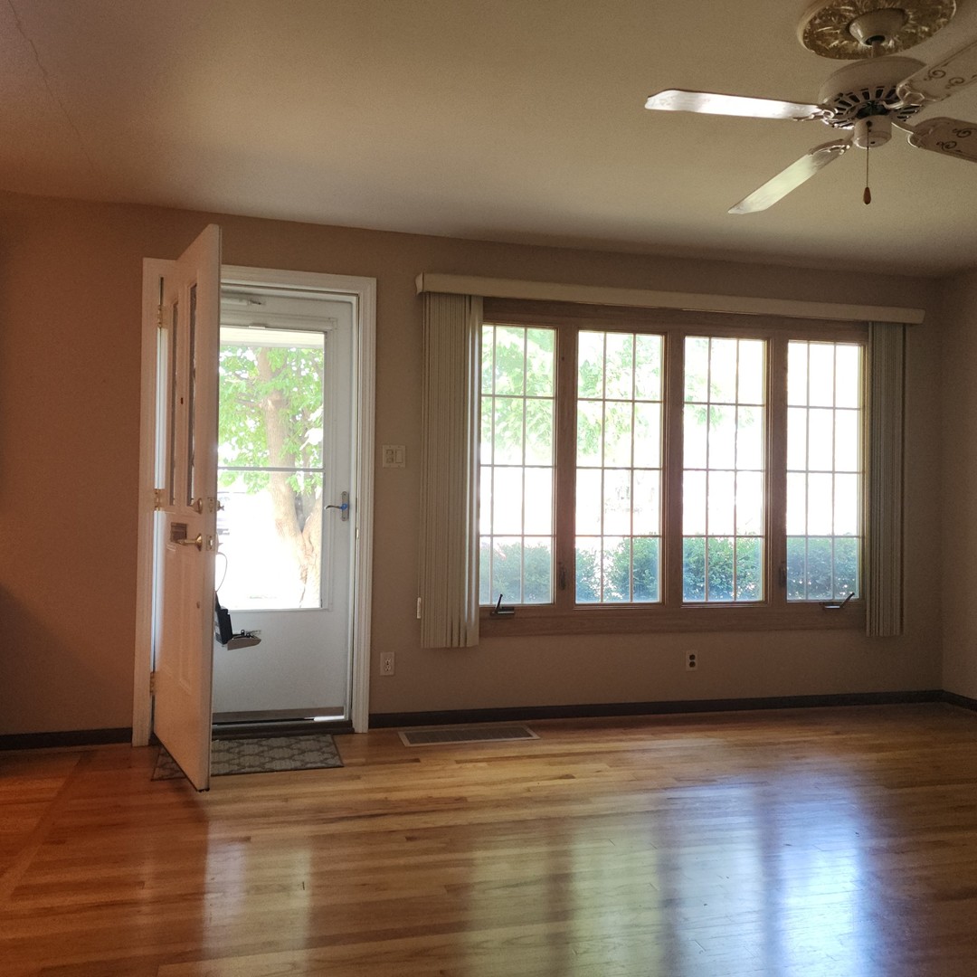 4605 West 84th Place Chicago, IL 60652 - Photo 5 of 30 an empty room with wooden floor and windows