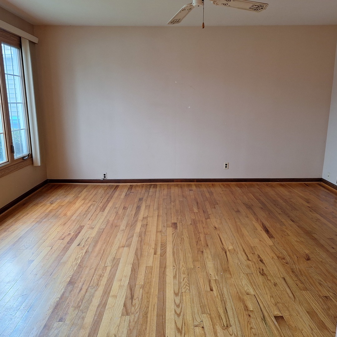 4605 West 84th Place Chicago, IL 60652 - Photo 6 of 30 an empty room with wooden floor and windows