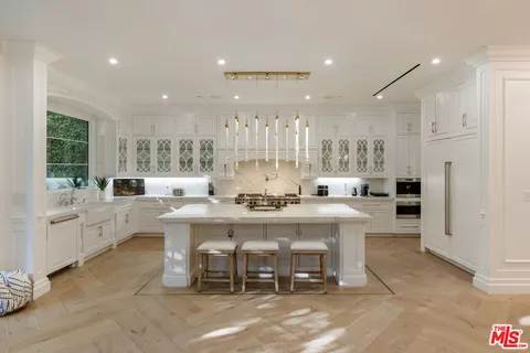 a large kitchen with a table and chairs