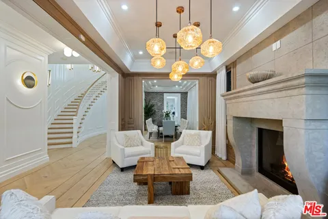 a living room with couch a fireplace and a chandelier