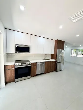 a kitchen with stainless steel appliances a refrigerator a stove a sink and a microwave