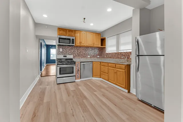 a kitchen with stainless steel appliances a refrigerator sink and microwave