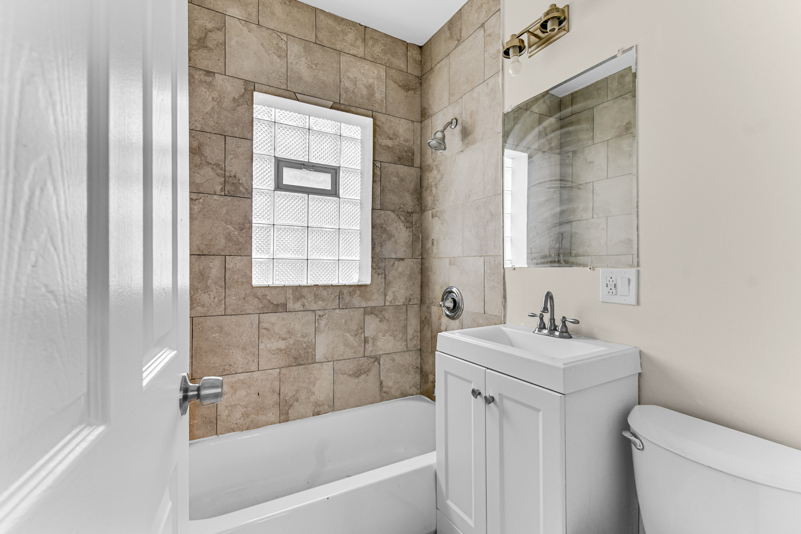 8922 South May Street Chicago, IL 60620 - Photo 9 of 23 a bathroom with a sink a toilet and shower