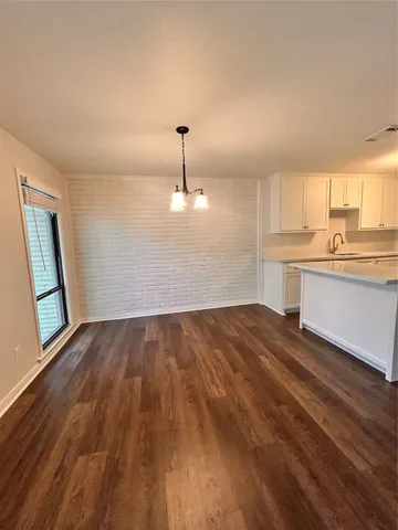 a view of a kitchen with a sink and dishwasher wooden floor