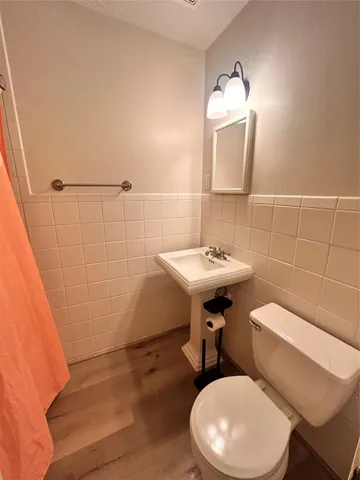 a bathroom with a sink a toilet and mirror