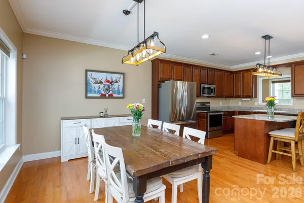 a view of a dining room with furniture a chandelier and wooden floor