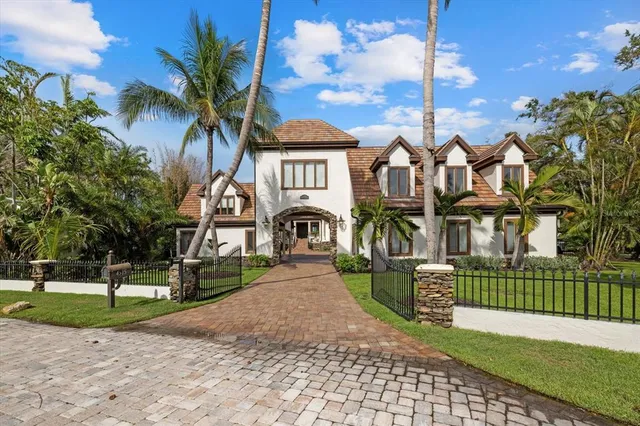 a view of a brick house next to a yard with a fountain