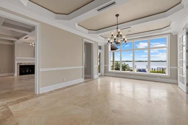 a view of a hallway with wooden floor and a chandelier