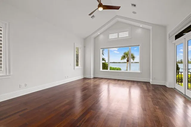 an empty room with a window and a ceiling fan