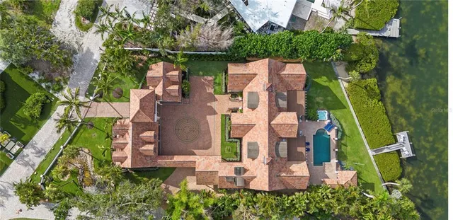 a aerial view of a house with swimming pool a yard and a fountain
