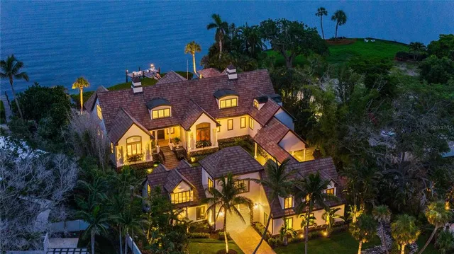 a large white kitchen with stainless steel appliances granite countertop a stove and a sink